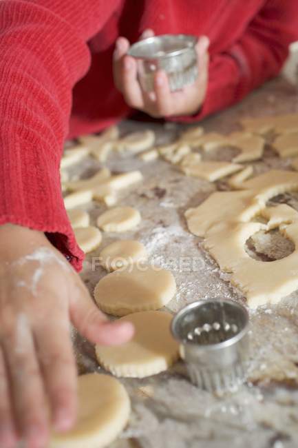 Child cutting biscuits — Stock Photo
