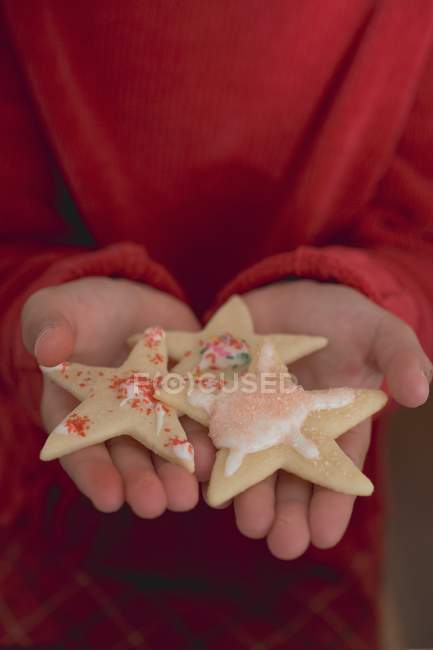 Child holding Christmas biscuits — Stock Photo