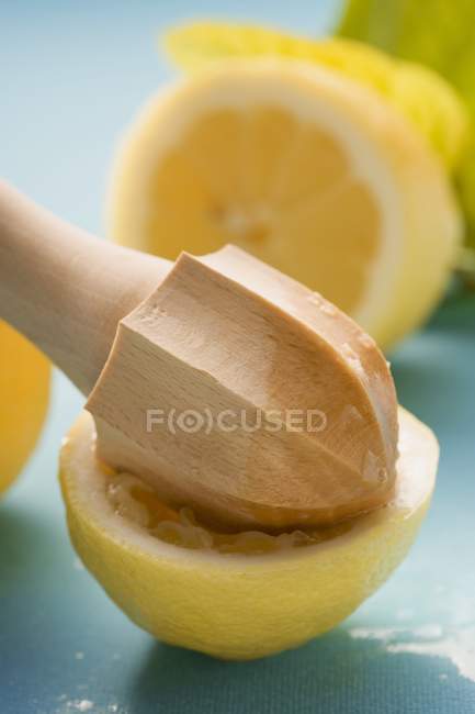 Exprimido medio limón con exprimidor de cítricos - foto de stock