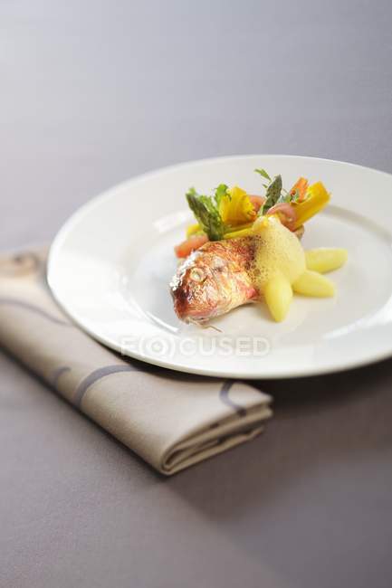 Vista de primer plano del salmonete rojo con verduras en el plato - foto de stock