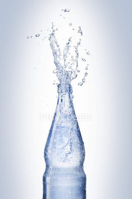 Agua salpicando de la botella - foto de stock
