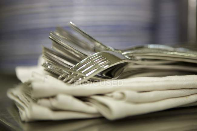 Closeup view of forks heap on fabric napkins — Stock Photo