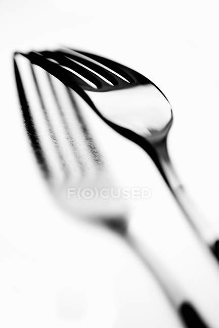 Primo piano vista di una forchetta metallica con riflessione su sfondo luminoso — Foto stock