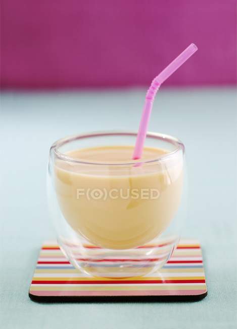 Крупный план манго Ласси в стакане с соломинкой — стоковое фото