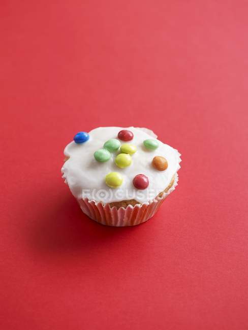 Cupcake con coloridos granos de chocolate - foto de stock