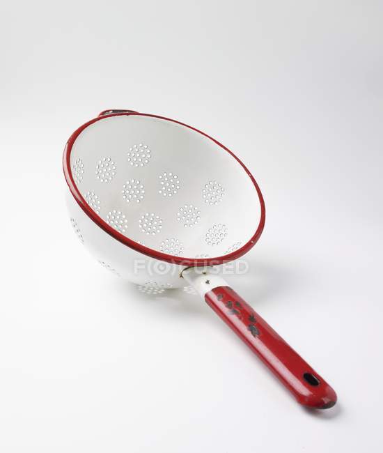Closeup view of one enamel colander on white surface — Stock Photo