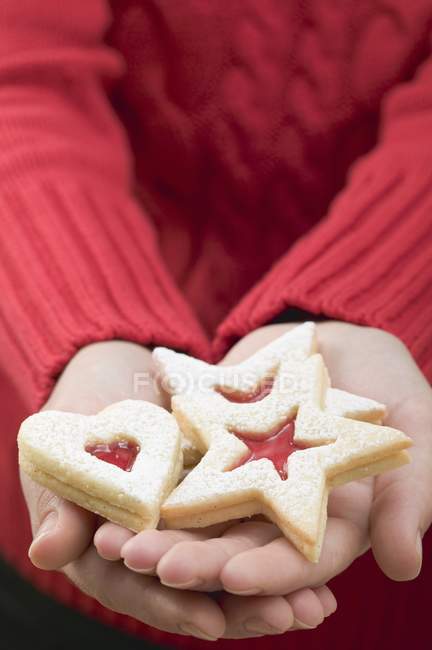 Hands holding biscuits — Stock Photo