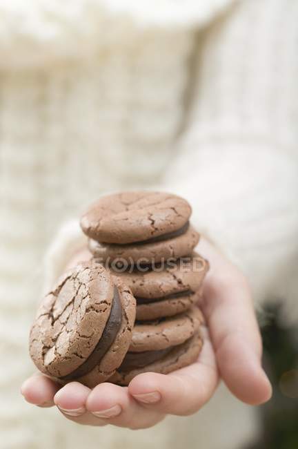 Mão segurando macaroons de chocolate — Fotografia de Stock