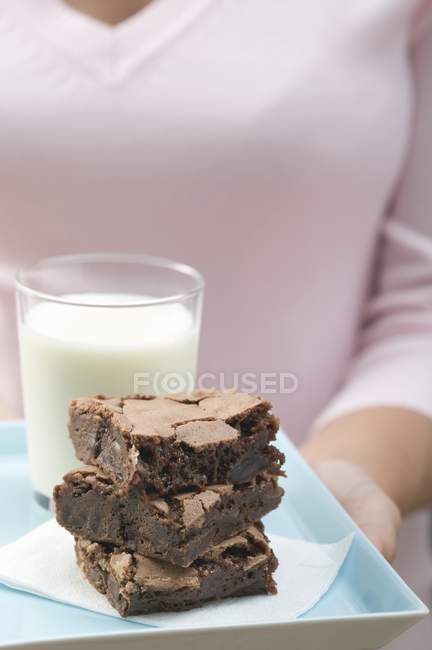 Woman holding stack of brownies serving — Stock Photo