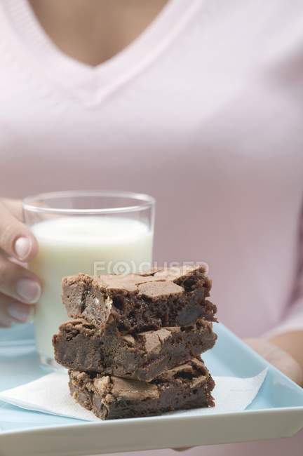 Woman holding stack of brownies serving — Stock Photo