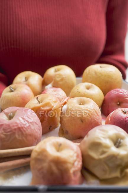 Mulher segurando maçãs assadas — Fotografia de Stock