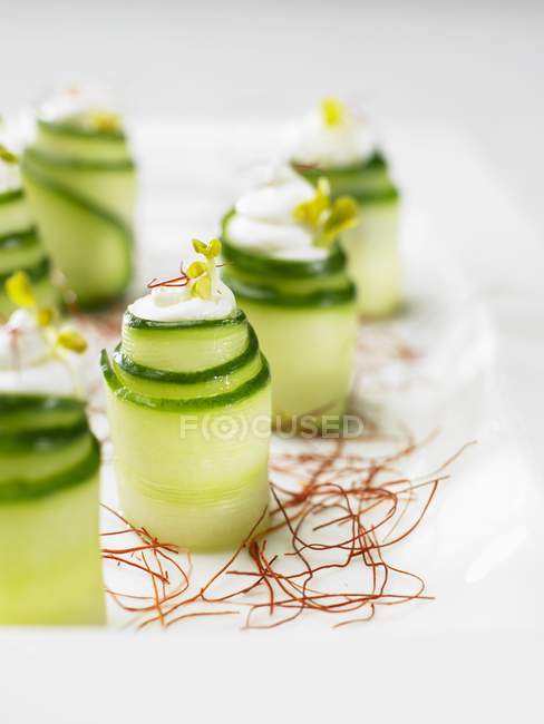 Rotoli di cetriolo su zafferano su piatto bianco — Foto stock