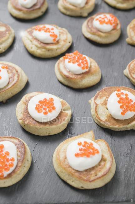 Buñuelos con crema agria y caviar - foto de stock