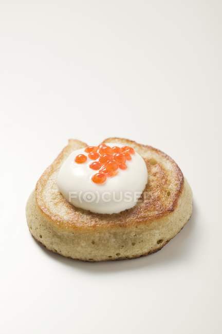 Fritter with sour cream and caviar — Stock Photo