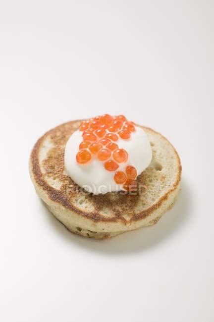 Fritter with sour cream and caviar — Stock Photo