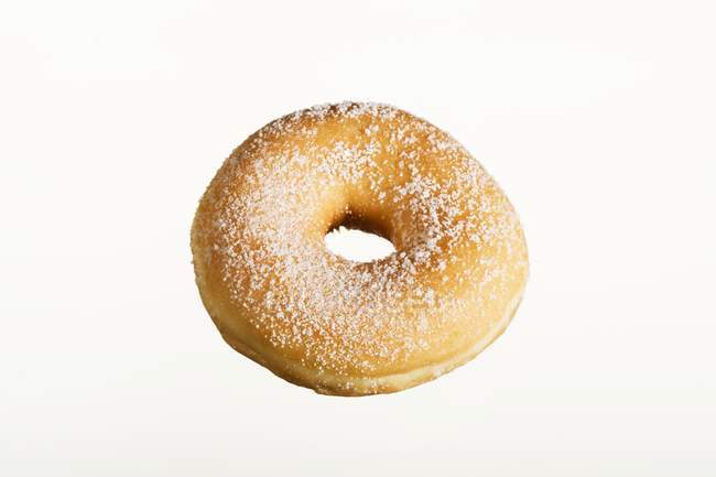 Sugared doughnut on white table — Stock Photo
