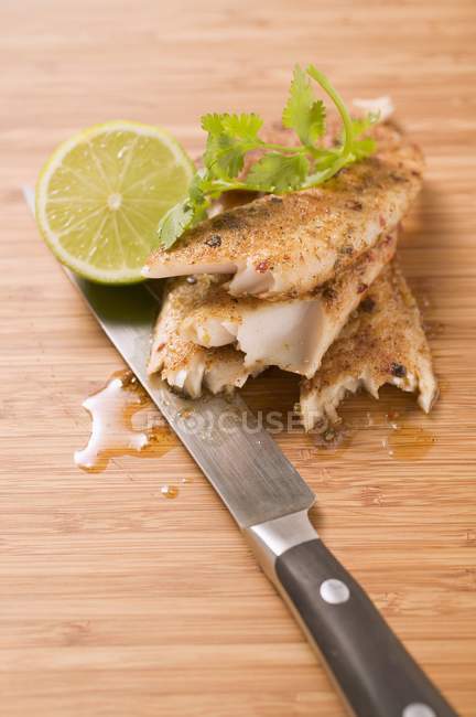 Closeup view of spicy pangasius fillet with lime and coriander leaves — Stock Photo