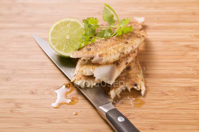 Closeup view of spicy pangasius fillet with lime and coriander leaves — Stock Photo