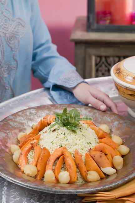 Donna che serve couscous con zucca — Foto stock