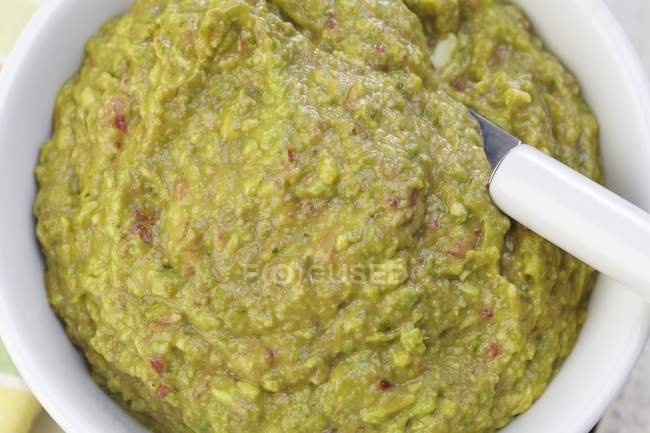Bowl of Guacamole with a Spoon view From Above in white dish with spoon — Stock Photo