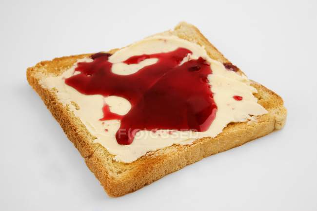 Vue rapprochée des toasts beurrés avec confiture sur la surface blanche — Photo de stock