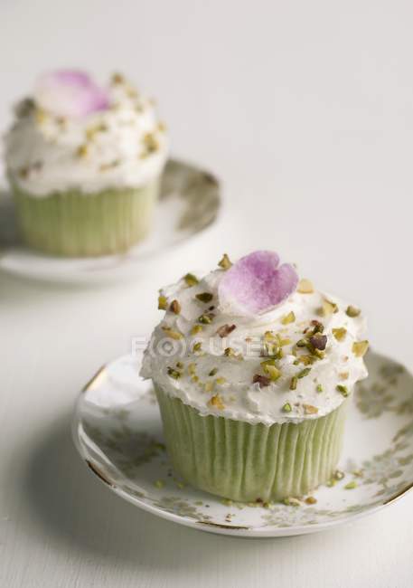 Cupcakes decorados con pétalos de rosa caramelizados - foto de stock