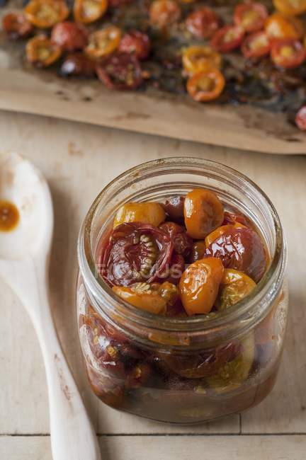 Slow Roasted Cherry Tomatoes in a Glass Jar; Sheet of Roasted Cherry Tomatoes — Stock Photo
