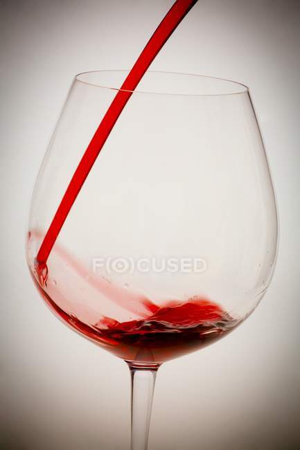 Vinho tinto derramando em vidro — Fotografia de Stock