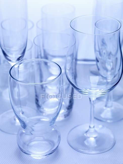Nahaufnahme verschiedener leerer Gläser auf blauer Oberfläche — Stockfoto