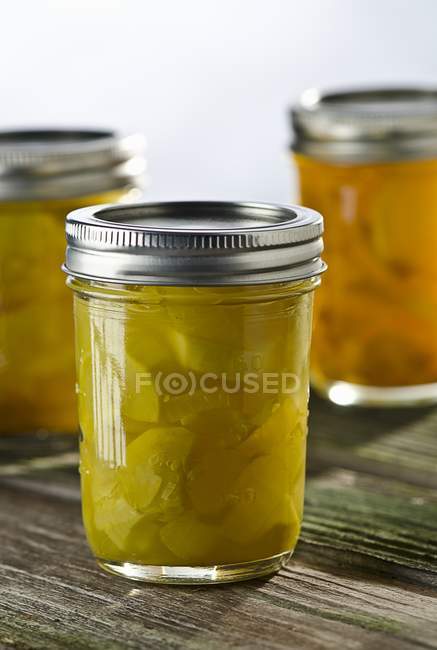 A Jar of Pickled Squash on wooden surface over white background — Stock Photo