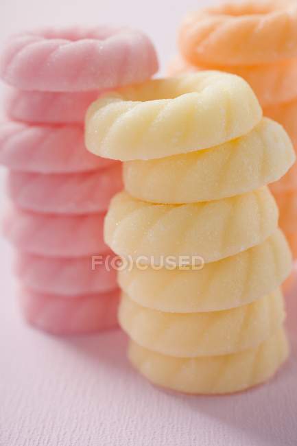 Vista de primer plano de los anillos de azúcar de color apilados - foto de stock