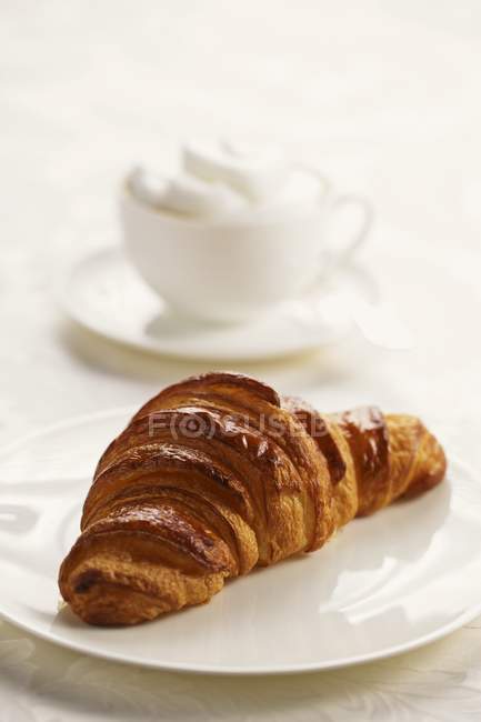Fresh croissant on plate — Stock Photo