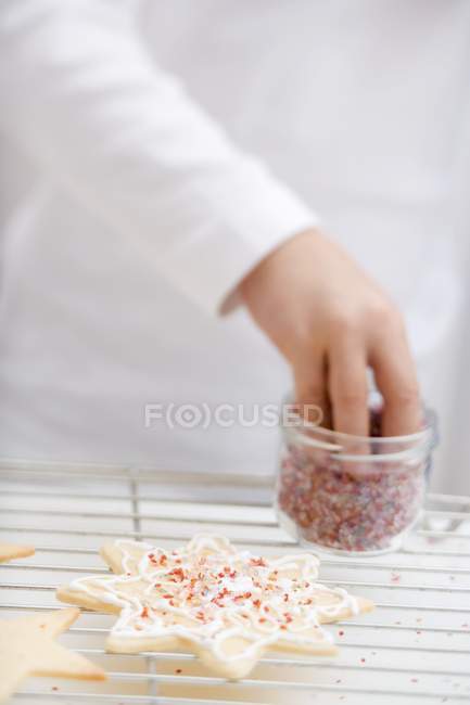 Child decorating Christmas biscuit — Stock Photo