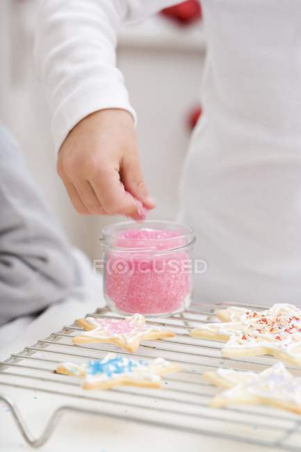 Child decorating Christmas biscuit — Stock Photo