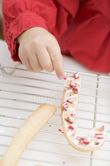 Girl decorating biscuits — Stock Photo