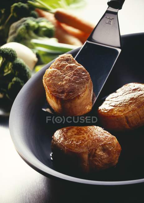 Filets de porc rôtis dans un bol avec spatule — Photo de stock