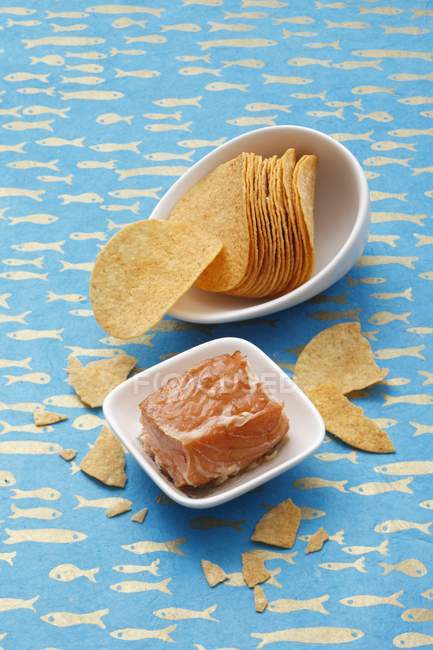 Vista elevata di pesce e patatine fritte in piatti bianchi su superficie blu fantasia — Foto stock