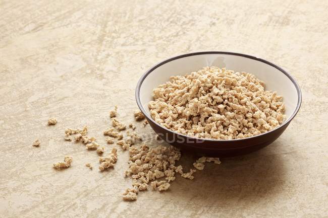 Vista elevata di granuli di soia in ciotola e sulla superficie beige — Foto stock