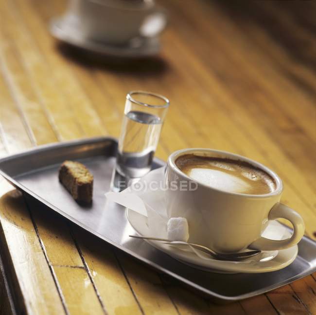 Cappuccino and grappa on tray — Stock Photo