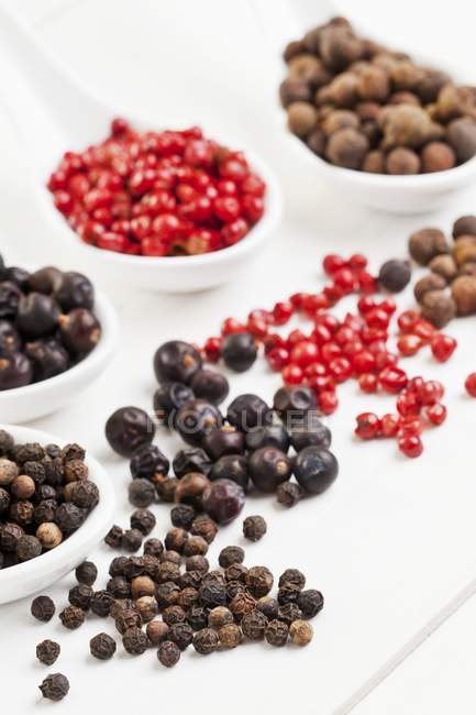 Closeup view of allspice berries with pink pepper, juniper berries and black peppercorns — Stock Photo