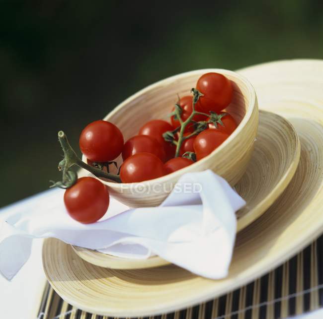 Cóctel de tomates en cuenco de madera - foto de stock