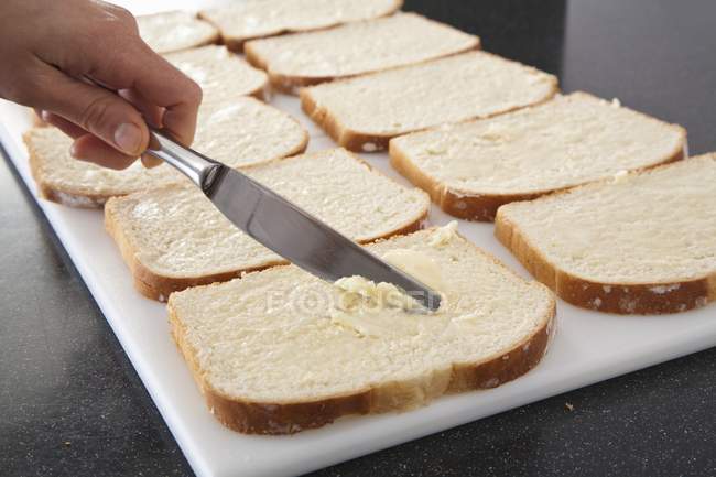Butter auf Brot verteilen — Stockfoto