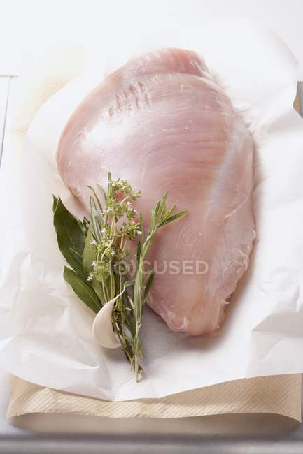 Turkey breast with herbs and garlic cloves — Stock Photo