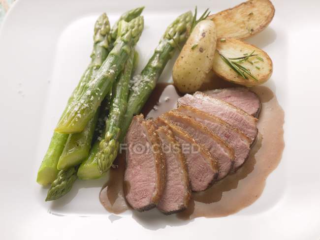 Duck breast with asparagus and rosemary potatoes — Stock Photo