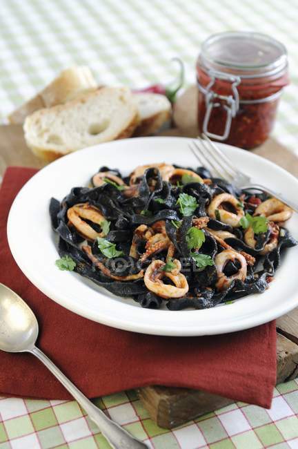 Black tagliatelle pasta with squid — Stock Photo