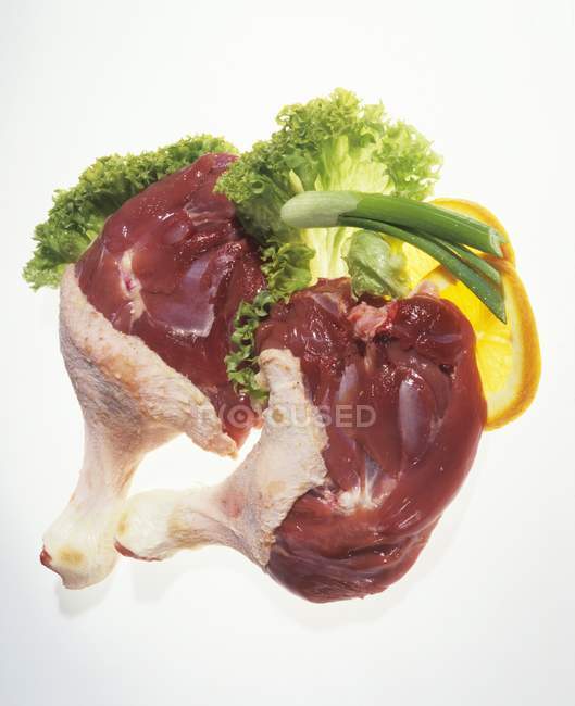 Pattes de canard crues garnies de laitue et d'orange — Photo de stock