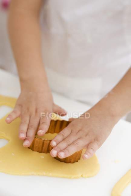 Visão de close-up de criança recortando um biscoito — Fotografia de Stock