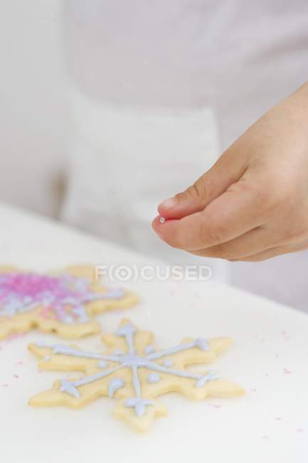 Kind dekoriert süßes Weihnachtsgebäck — Stockfoto