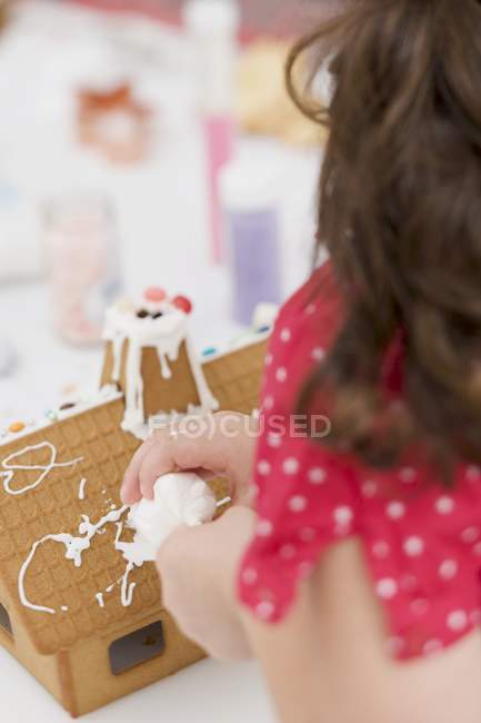 Decorating gingerbread house — Stock Photo