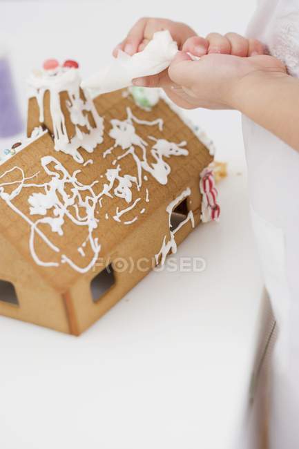 Decorating gingerbread house — Stock Photo